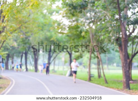 Blurred background of people running in park
