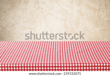 Empty table covered with red checked tablecloth overbrown cement wall background, for product display montage