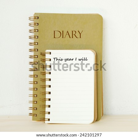 Blank note book with this year I will words and diary book on table background