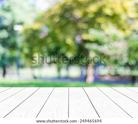Empty perspective white wood over blurred trees with bokeh background, for product display montage