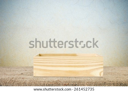 Wood storage box on table covered with sackcloth background, product display montage