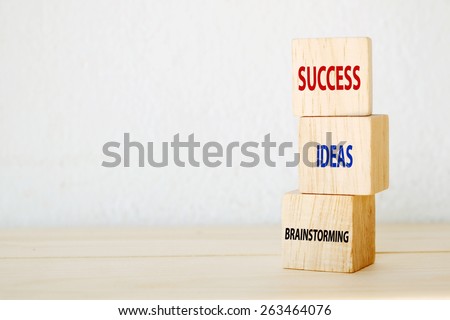 Brainstorming, ideas and success words on three wooden cubes, step to success in business concept