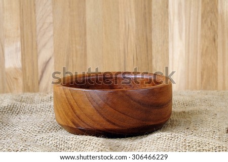 Empty wooden bowl on sack tablecloth, food display montage
