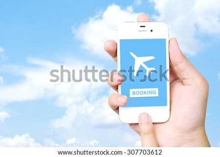 Hand holding mobile phone with airline tickets online booking on screen on screen over blue sky background, Business air travel, e-commerce and digital technology concept