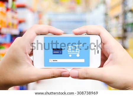 On line shopping on smart phone screen over blur supermarket background, business, E-commerce, technology and digital marketing background