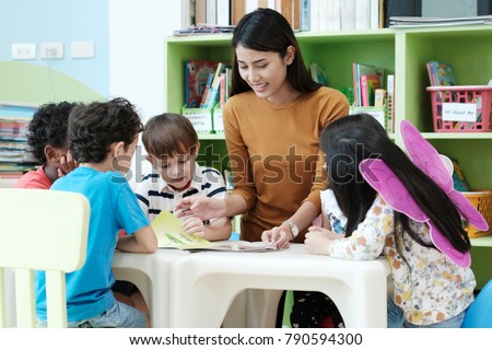 Young asia woman teacher teaching kids in kindergarten classroom, preschool education concept