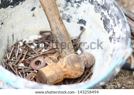 old hammer and neils in cement bucket