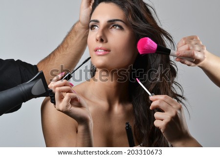 Beautiful young woman getting her hair and make up done, beauty concept, studio shot