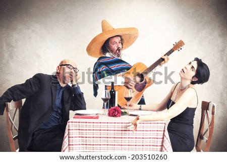 bored couple at dinner oblyed to listen to a mexican musician