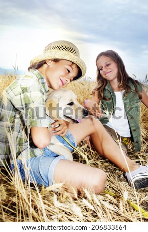 brother and sister in a wheat field with a dog
