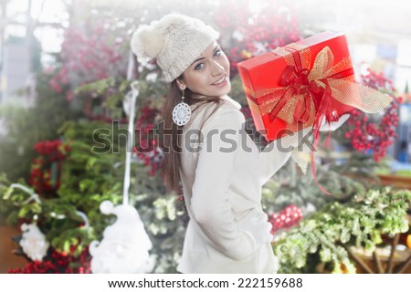 Young woman shows her gift packs inside a Christmas shop