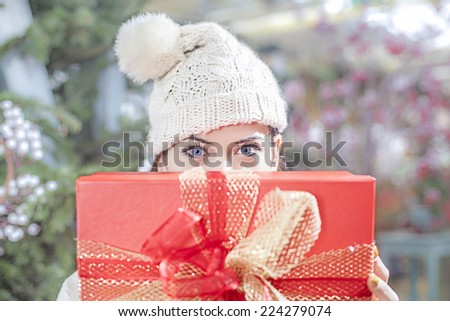 Young woman shows her gift packs inside a Christmas shop