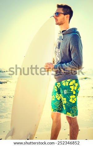 pensive surfer  waiting for the perfect wave on the beach