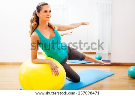 Woman making body exercises on a yellow ball