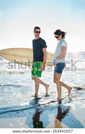 couple of surfers running on the seashore