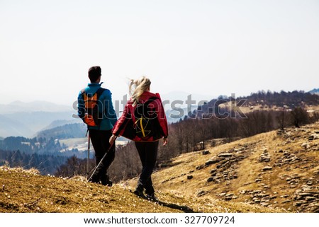 couple of hikers walking in the mountains breathing clean air