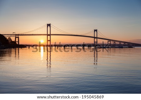Morning blue and orange sunrise under the Newport Pell Bridge seen from Jamestown, Rhode Island, USA. Horizontal image. / Newport Bridge Sunrise.