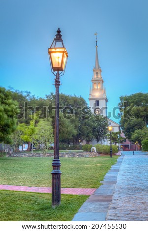 Historic Trinity Church and street lamp in outdoor park at night in Newport, Rhode Island, USA. /  Trinity Church and Street Lamp