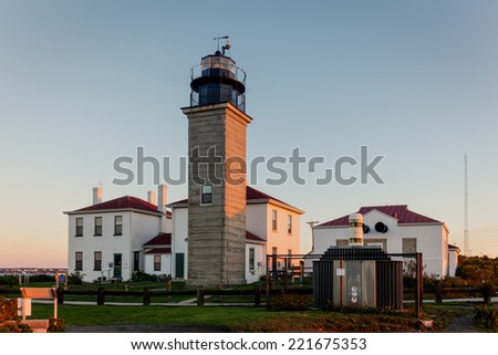 Beavertail State Park and lighthouse at dawn on a cold fall morning before sunrise in Rhode Island, USA. This is a HDR image with warm orange glow on the buildings. / Beavertail Lighthouse Sunrise