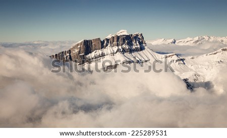 Aerial view of tall, snow covered, mountain peak in the French Alps, Europe. / Aerial Snow Covered Mountain Landscape in French Alps