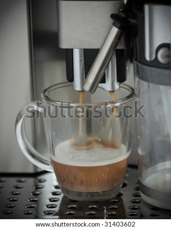 delicious cups of espresso being poured from a domestic espresso machine