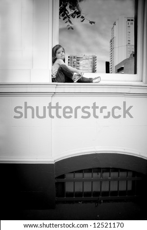black and white of a toddler on a window ledge
