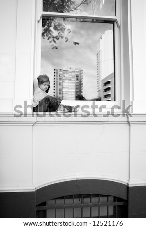 black and white of a toddler on a window ledge