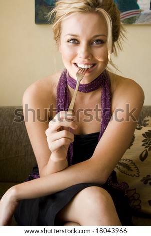 beautiful young woman sitting in a cafe eating cake