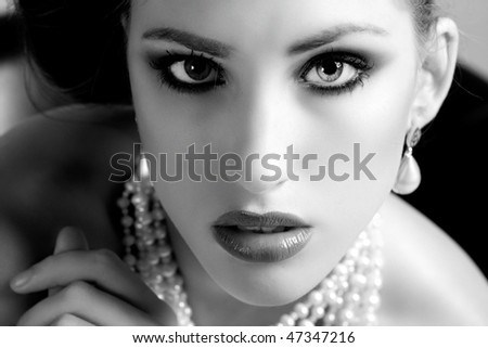 Attractive young woman wearing a pearl necklace and earrings. Horizontal shot.