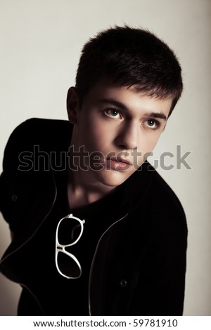 stock photo : Teenage boy with short dark hair models for the camera. He is