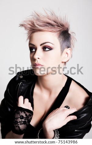 An attractive young woman with pink hair wearing a leather jacket and lace glove. Vertical shot.
