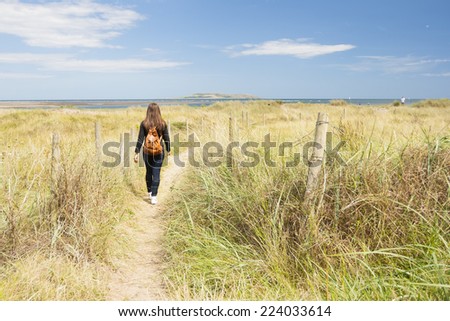 Young woman walking along the footpath near the beach
