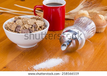 Cereals, coffee, cupcake and sugar spilled on the table