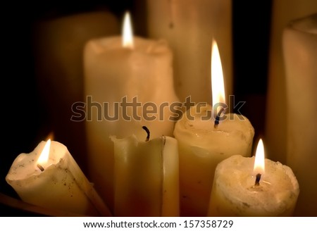 Several wax candles are slowly consumed.