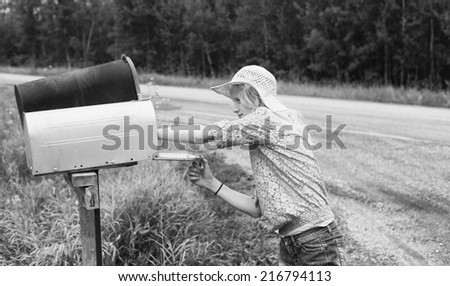 Young girl checking rural mailbox