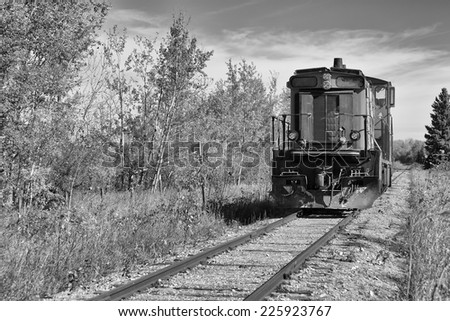 Train engine sitting on railway track black and white