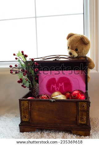 Small wooden treasure chest with open lid showing pink envelope