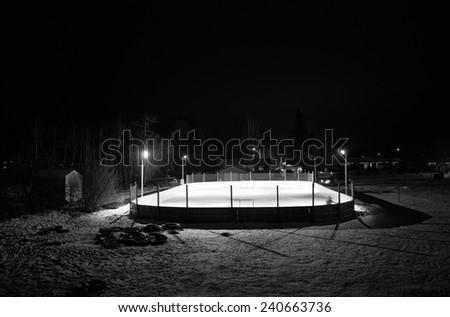 Outdoor ice hockey rink at night in black and white