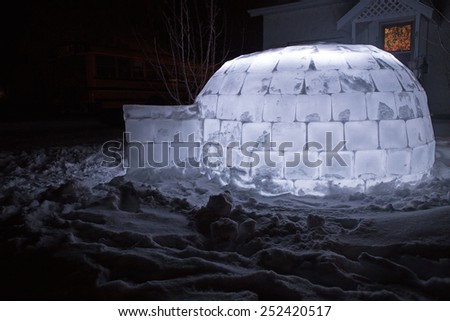 Homemade igloo lit up at night in front yard