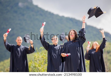 Students throwing graduation hats in the air celebrating
