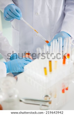 Scientists pipetting and microscoping in the life science research laboratory (biochemistry, genetics, forensics, microbiology..)