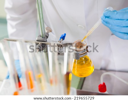 Attractive young female scientist  pipetting  in the life science research laboratory (biochemistry, genetics, forensics, microbiology..)