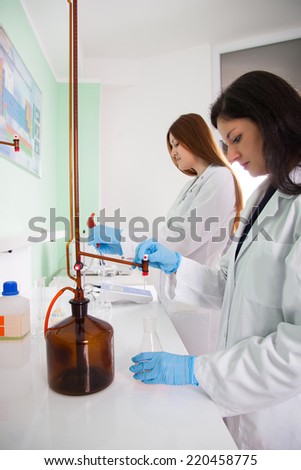 beautiful researcher carrying out research experiments in a chemistry lab (color toned image)