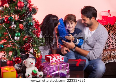 Smiling parents giving Christmas present to son at home Smiling parents giving Christmas present to son at home