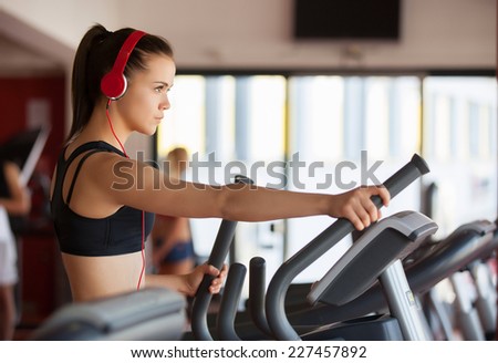 Woman exercising at the gym on a cross trainer