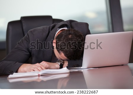 Tired businessman sleeping on a laptop