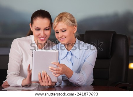 Businesswomen Meeting Around Table In Modern Office