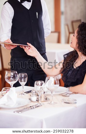 Cheerful couple with menu in a beautiful restaurant making order