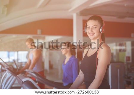 Fitness running people. Sports people running on the treadmill at the gym. Athletes wearing sportswear and running in the gym a rear.