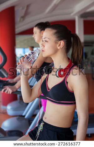 young women drinking water after sports. Fitness gym.